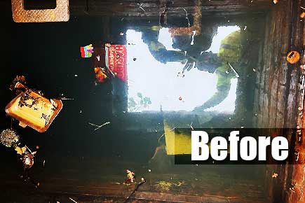 Close-up view of a blocked brick-built sewer in Sheffield, almost overflowing with water and floating waste � including a drinks can, crisp packets and fast-food boxes � in urgent need of specialist removal.